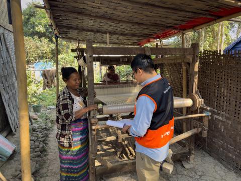 A World Vision stands with a woman over a sewing machine