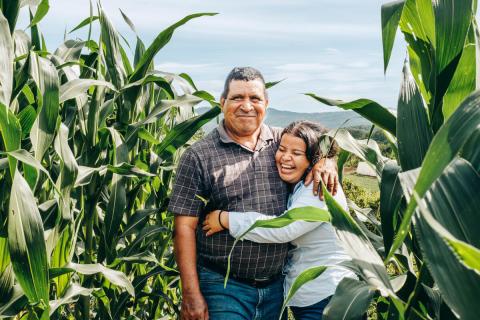 Don Antonio standing in his field with his wife