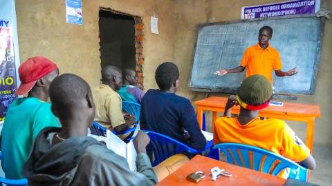 john conducting an english class session with fellow refugges