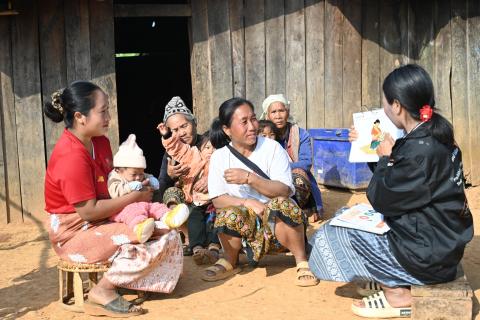 Village Health Volunteer in Cambodia shares maternal health guidance with four women and their children.