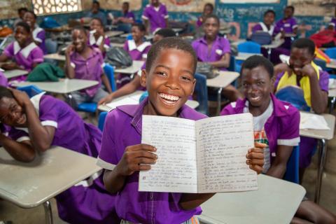 Lameck proudly shows how much his handwriting has improved. Malawi, 2025.