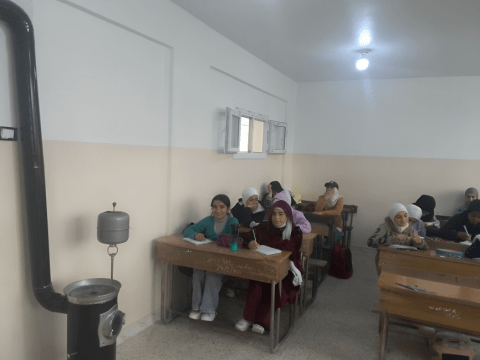 Hayat (in red) happily studying in class next to the new heater