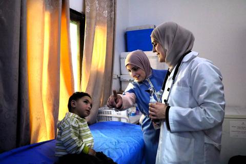 A Community Health Worker and a nurse monitor the development of a child in a clinic in the West Bank