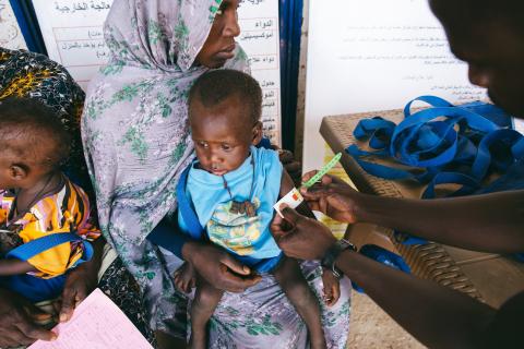 At El Ferduouse Clinic in South Darfur, health staff measure a young child’s arm to understand the level of malnutrition and provide the right care.