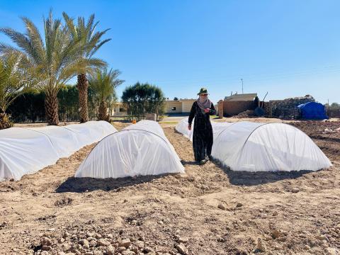 Photo of Farah next to the greenhouses