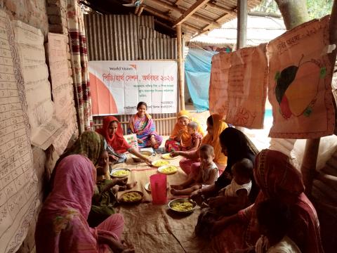A group of mothers and young children sitting together during a World Vision PD Hearth session in Bangladesh. 