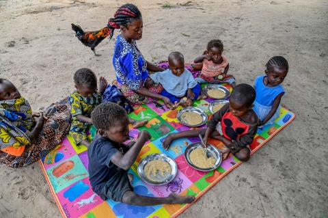 Lucie sharing a warm lunchtime moment with her son Médar and other children / DRC/ 2025.