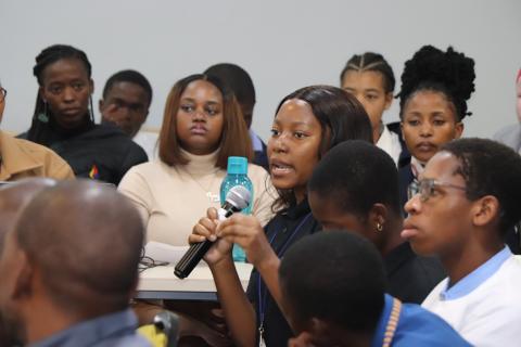 A young women speaking in a crowd.