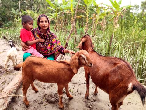 Shahida stands proudly with her child alongside her flourishing livestock.