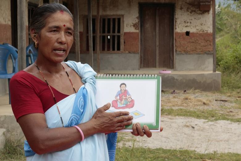A child health worker holds a training document
