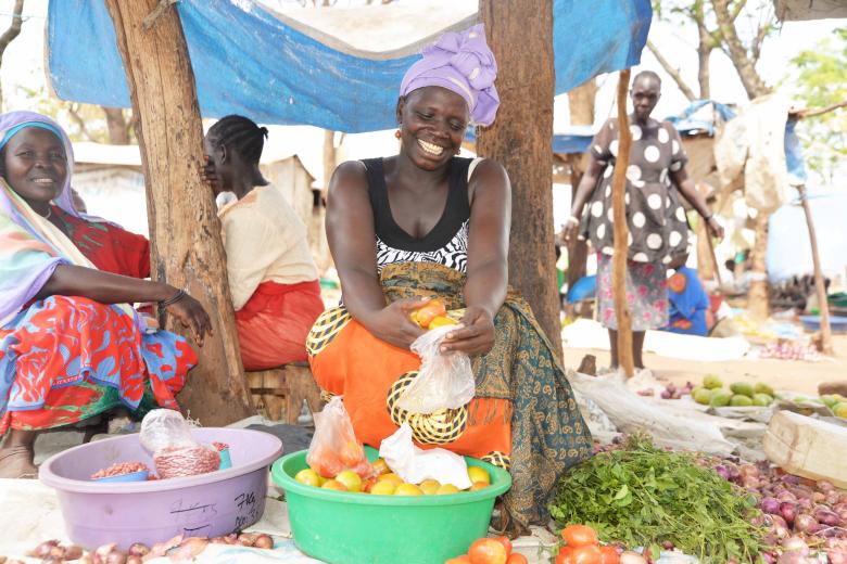 Yabang sorting tomatoes for her customer