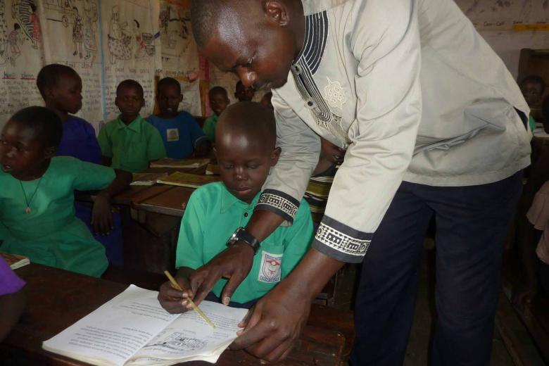 John Omara, teaching one of his students how to pronounce a word.
