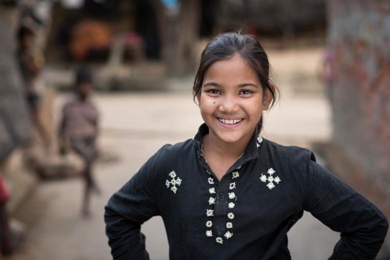 Preeti standing near her home in India