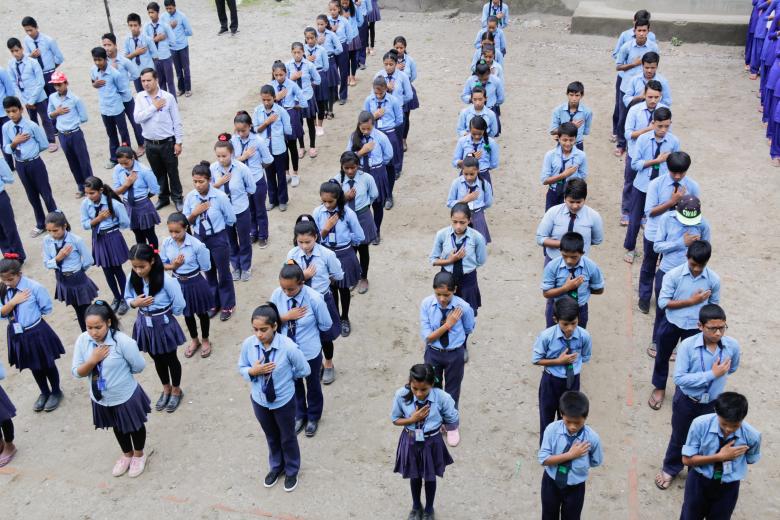 Students of Kalika Devi School sing the national anthem during morning assembly