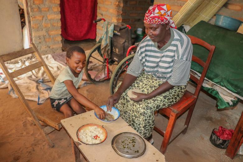 Josephine and her grandchild Maggie eating Nshima-- the staple food in Zambia made from finely ground corn meal, called mealie meal.