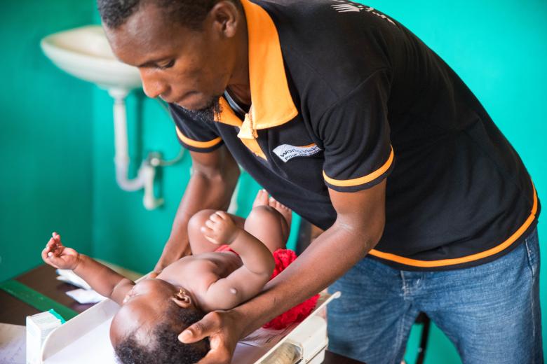 Un agent de World Vision prend le poids d'un bébé