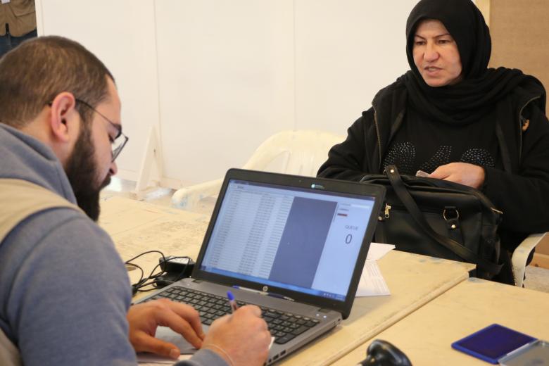 World Vision staff collect information from a woman