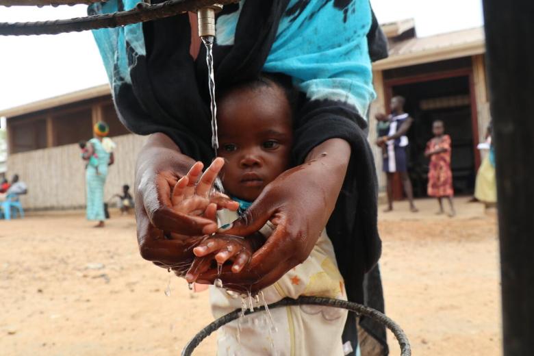 Mother washing he child's hand with clean water
