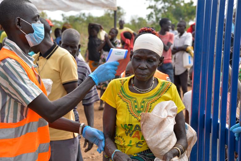 A volunteer checking beneficiary temperatures
