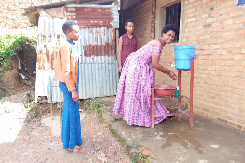 Chantal washes her hands as her little sisters look on
