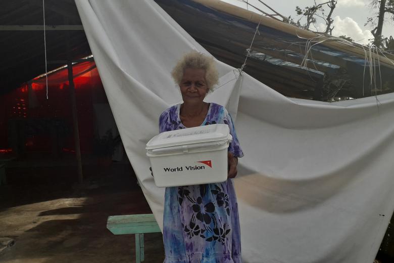 Elcy in front of her church with the hygiene kit