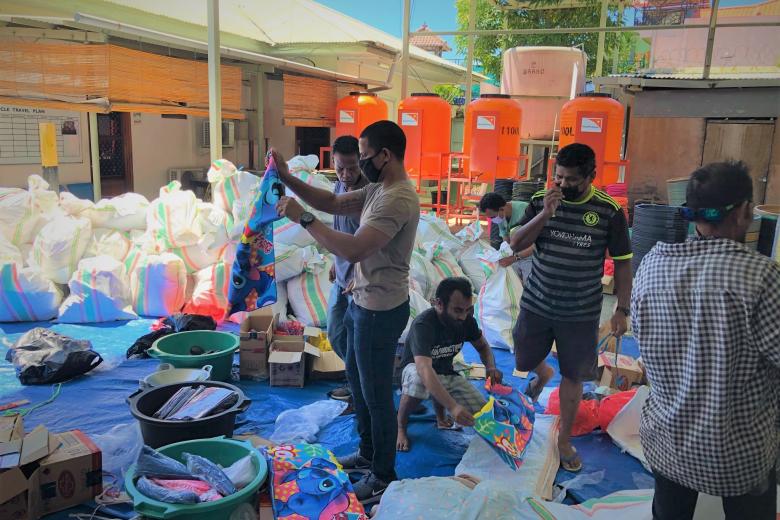 World Vision’s Abilio Marques (standing in the middle while holding cloth) and the team packing the items.