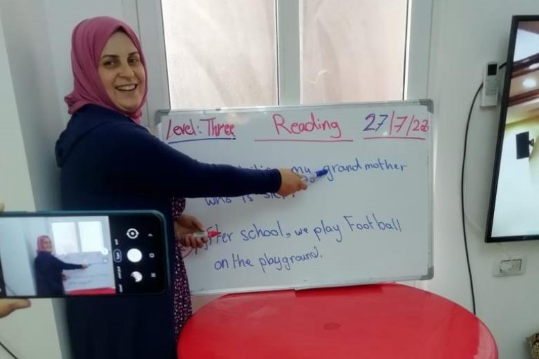 Nahed, remedial class teacher, explains a lesson on camera so as to send the video later to her students