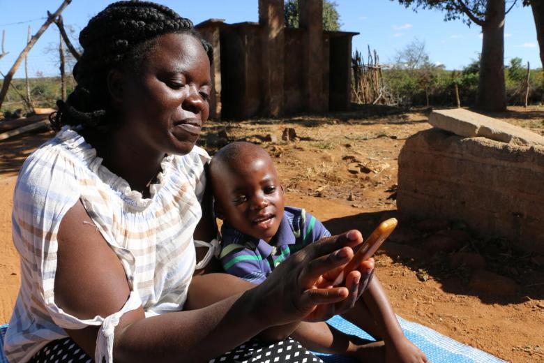 Mother and child use a phone for information and education in Zimbabwe