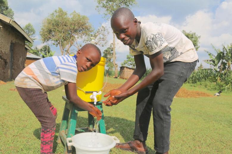 Raphael washing his hands with a younger child in Kenya