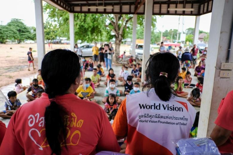 world Vision staff sit next to partner