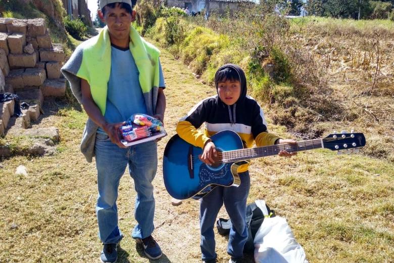 David in Peru plays his guitar given through World Vision