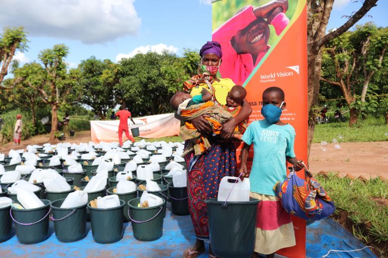 Anguista is holding her five months-old twins after receiving her non-food items kit