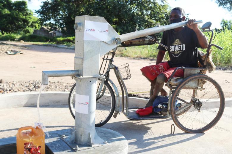 David is showing how he fetch water from the water point with a ramp that allows him to reach the crank through wheelchair