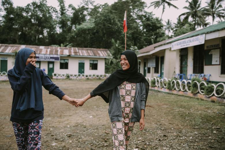 Young peacemaker girls in the Phippines hold hands