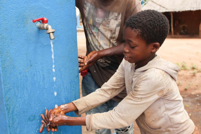 Dercio Chimoio showing running water from the system