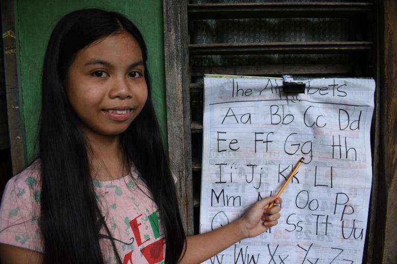 Mary Jane with the chart she uses to teach her sister during COVID-19 lockdowns