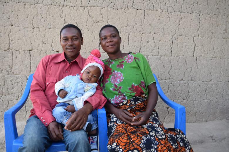 Family that learned the importance of exclusive breastfeeding sits with their happy and health baby in Tanzania