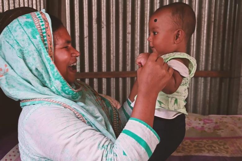 Mother who learned about exclusive breastfeeding smiles and plays with her health baby in Bangladesh