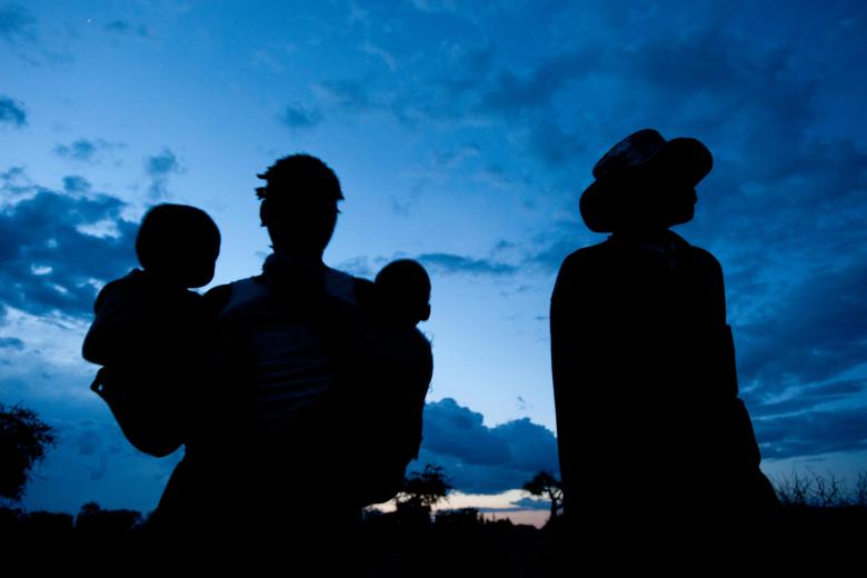 A family silhouetted against a blue sky