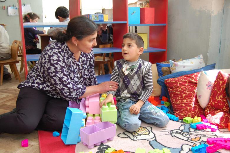World Vision staff help child with disabilities