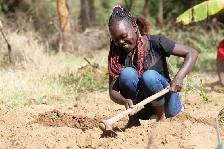 Ruth uses a hoe to prepare the ground
