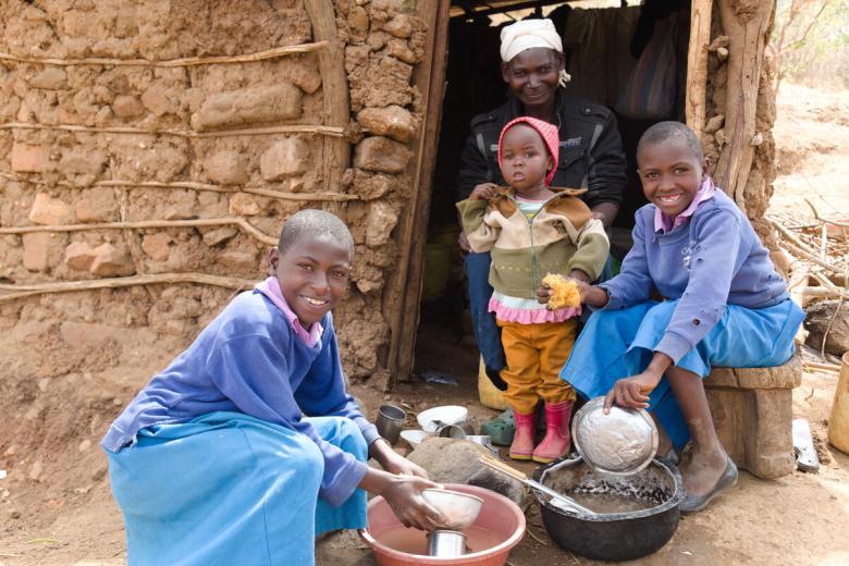 Anastacia and her daughters wash dishes after eating a small ration of maize.