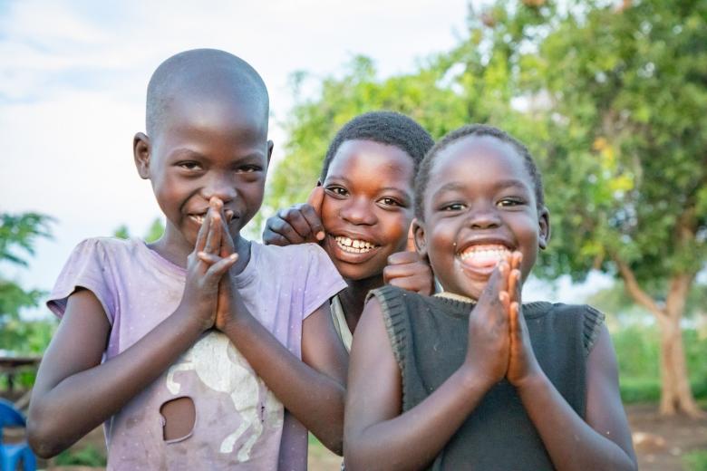 Children praying and smiling