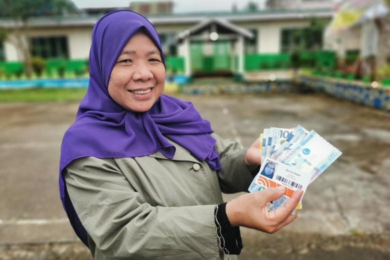 Lady showing money to the camera