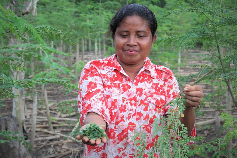 Smiling woman in Timor-Leste showing superfood