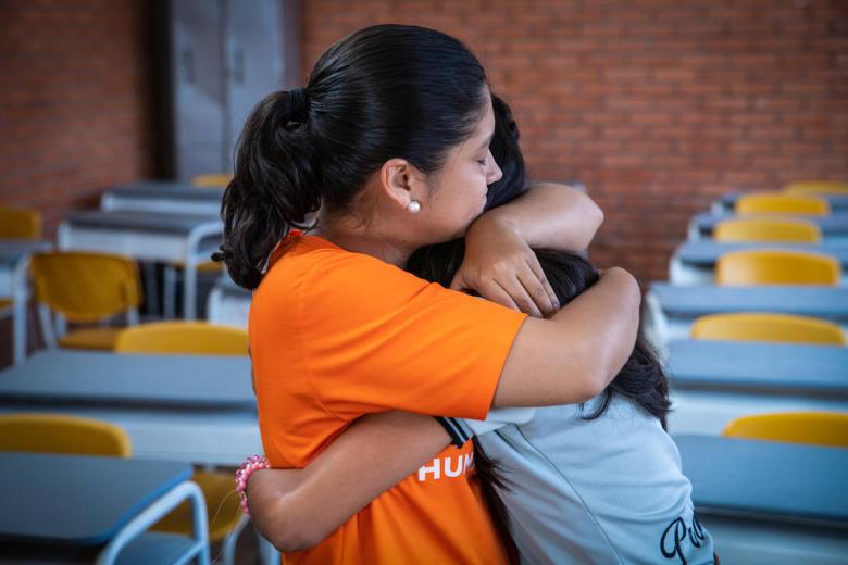 World Vision staff member hugs someone else