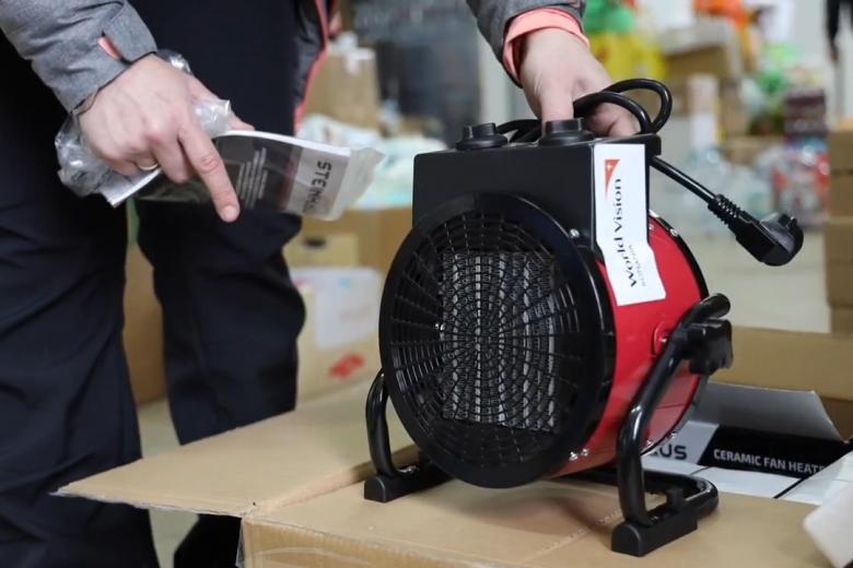 World Vision staff unboxes heaters