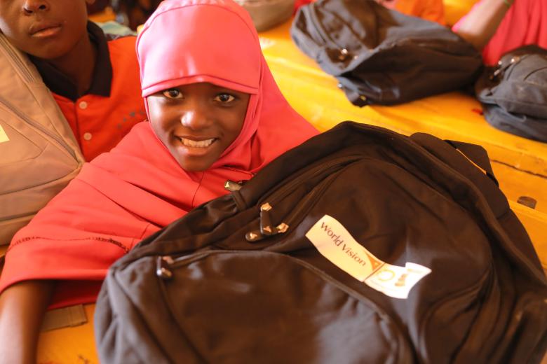 Sakina with the bag and desk she received from World Vision
