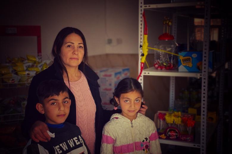 Azia in her store with her children
