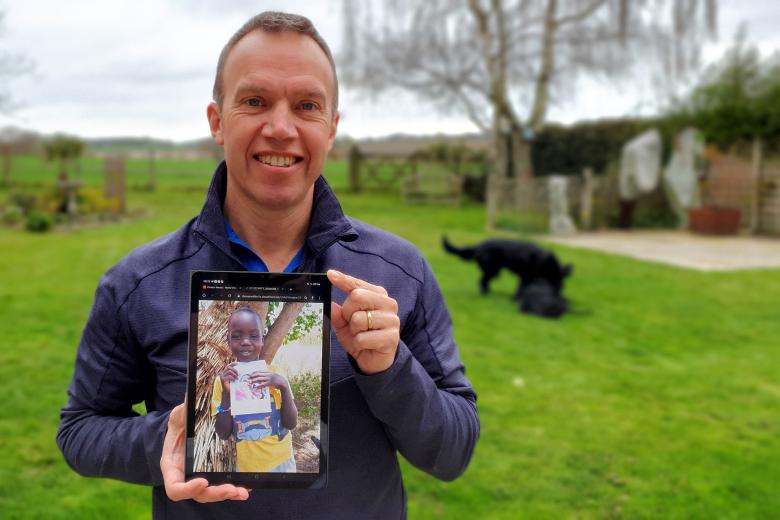 Marcus Frost holds up the picture of the child in Kenya who choose him to be his sponsor